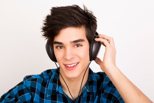 Young man listening music with headphones at home