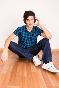 Young man listening music with headphones at home