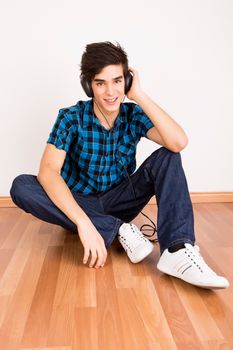 Young man listening music with headphones at home