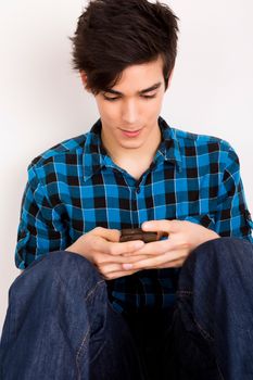Young man looking at his smart phone while text messaging