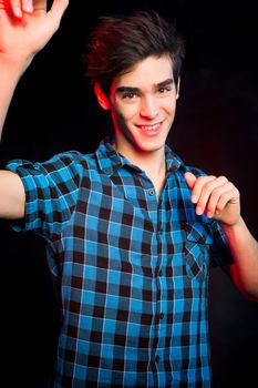 Young man dancing and enjoying music at disco