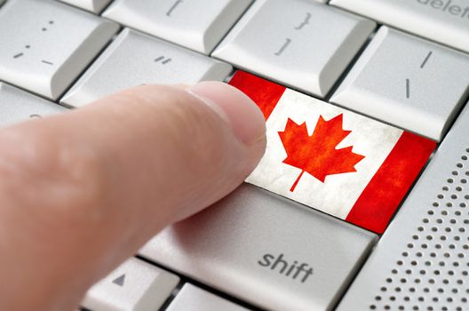 Business concept male finger pressing Canada enter key on metallic keyboard