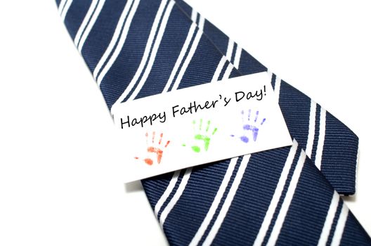 Happy Father's Day with colorful hand prints tag on blue tie over white background