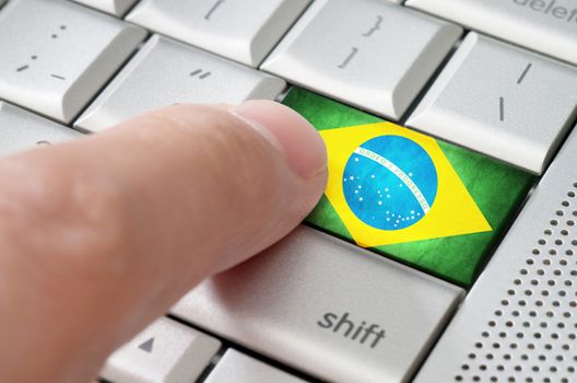 Business concept male finger pressing Brazil enter key on metallic keyboard