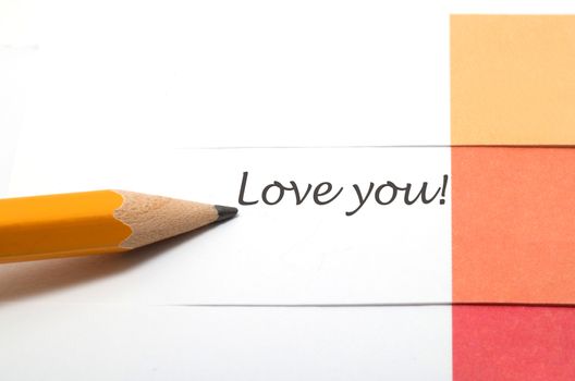 A note with love you text and a pencil