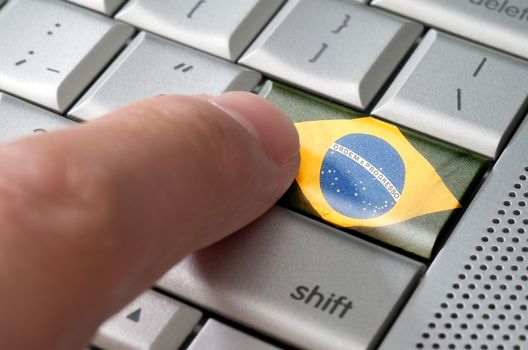 Business concept male finger pressing Brazil enter key on metallic keyboard