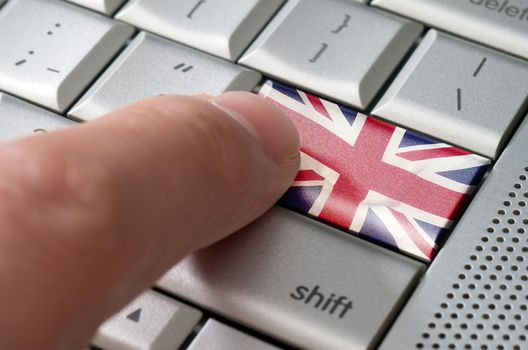 Business concept male finger pressing United Kingdom enter key on metallic keyboard