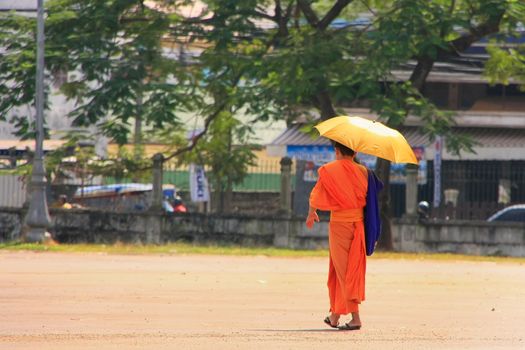 Monk with umbrella walking in the street, Vientiane, Laos, Southeast Asia