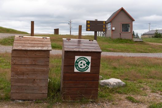 Two wooden garbage and recycle  bins in a skii resort during summer time