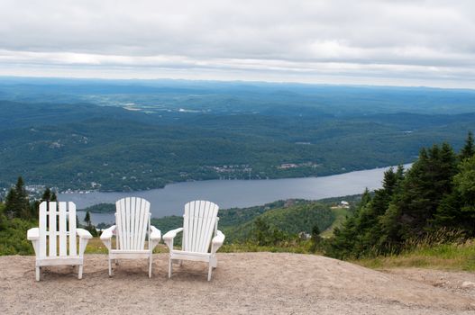 Chairs on top of mountain  at a ski resort during summer time depicting relaxing concept