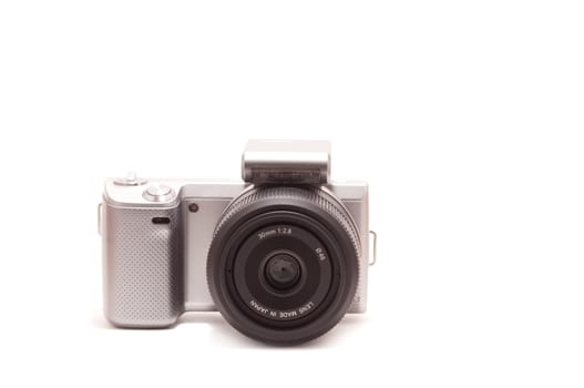 Mirrorless DSLR with 30mm lens isolated on white background