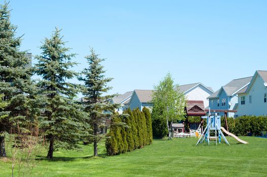 A typical American backyard with child playground during a sunny day