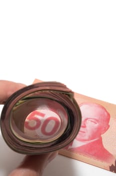 A roll of bank notes focusing on a 50 Canadian dollars