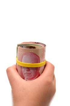 Hand holding a roll of 50 dollars Canadian with yellow plastic band over the eyes 