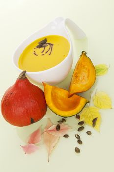 Culinary hokkaido pumpkin soup with hokkaido pumpkin, sees and leaves. Delicious seasonal autumn soup eating.