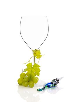 Empty wineglass with green grapes and wine stopper isolated on white background. Luxurious wine drinking background. 