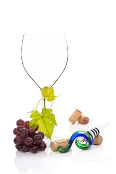 Wine glass, with cabernet sauvignon grapes, vine leaves wine stopper and wine corks isolated on white background. Culinary gourmet red wine drinking.