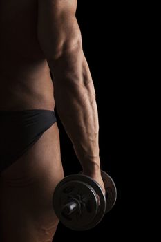 Sport and Fitness. Sexy bodybuilder holding dumbbell isolated on black background.