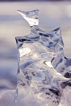 Light reflections in clear ice sculpture shaped by nature through repeated thaw and frost cycles