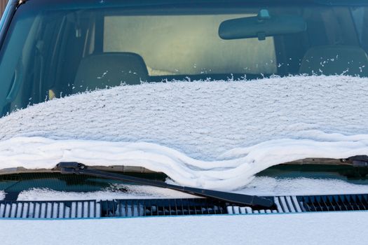 Fresh snow thawing and sliding on vehicle windshield developing ridges and wrinkles
