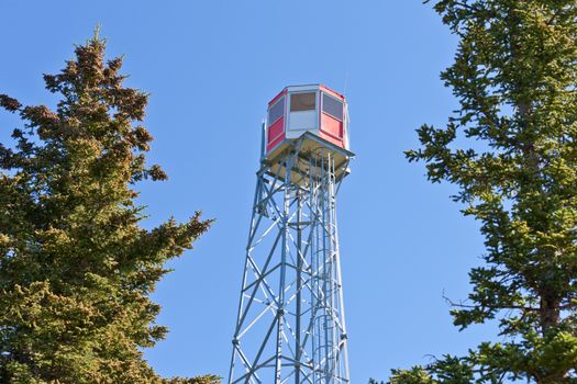 Forest fire watch tower tall architectural steel lookout structure overlooking forest of Rocky Mountains foothills, Alterta, Canada