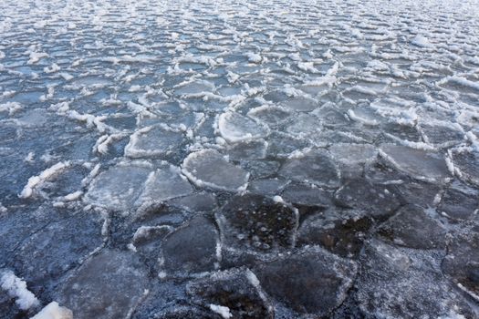 Ice floes floating on water surface of freezing lake nature background pattern texture abstract