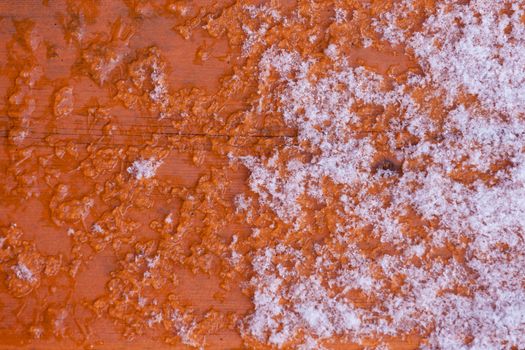 Winter nature background pattern abstract contrast of fresh snow melting on wet wooden surface
