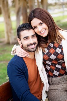 Young romantic couple on a bench in park