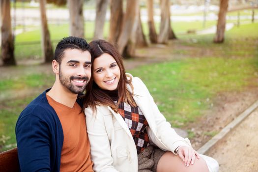 Young romantic couple on a bench in park