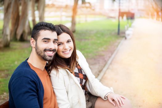 Young romantic couple on a bench in park