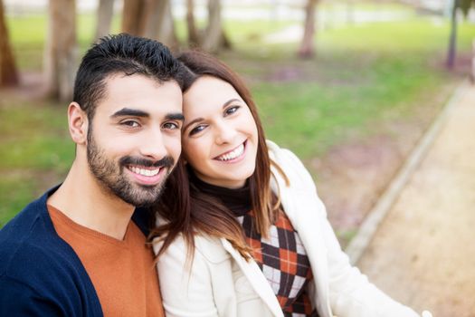 Young romantic couple on a bench in park