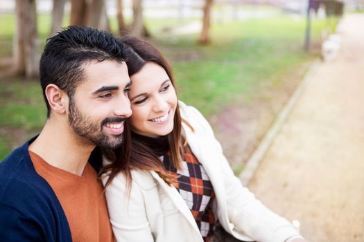 Young romantic couple on a bench in park