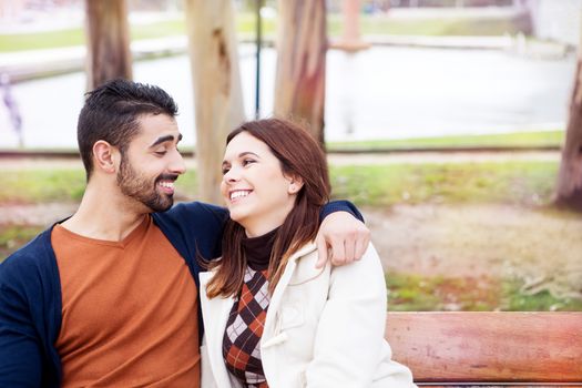 Young romantic couple on a bench in park