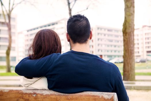 Young romantic couple on a bench in park