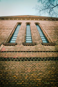 Retro Filtered View From Below Of Red Brick Church Tower Windows