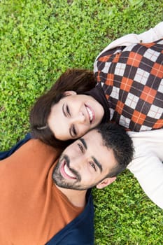 Happy couple relaxing on the grass park