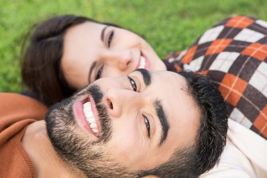 Happy couple relaxing on the grass park