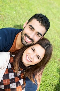 Happy couple relaxing on the grass park