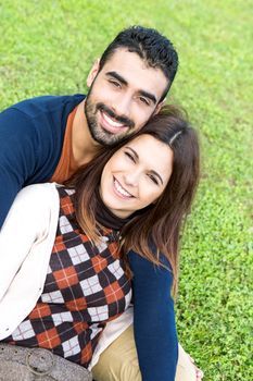 Happy couple relaxing on the grass park