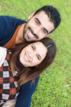 Happy couple relaxing on the grass park