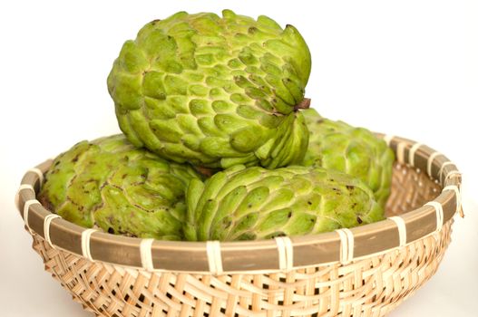 Custard apples in a bamboo basket isolated on white background