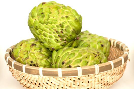 Custard apples in a bamboo basket isolated on white background