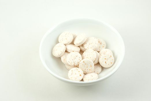 Small dish containing vitamin C pills