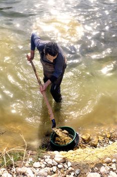 Gold digger in France in the region of Cevennes and the department of Gard in the middle of the river called Le Gardon.