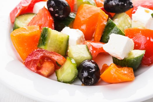 Greek salad with feta cheese macro on white plate