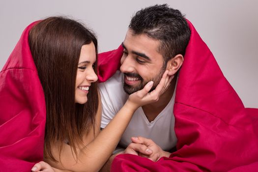 Young love couple relaxing together in bed 