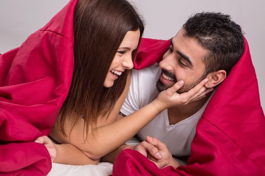 Young love couple relaxing together in bed 