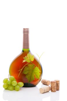 Luxurious rose in green round bottle without label with green wine grapes and grape leaves and various wine corks isolated on white background. Culinary gourmet wine still life.