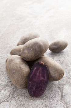 Raw culinary potatoes on natural stone background. Culinary healthy vegetable eating.