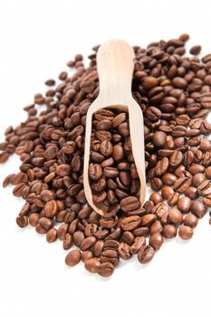 Pile of coffee beans and coffee beans on wooden scoop isolated on white background. Traditional coffee background.